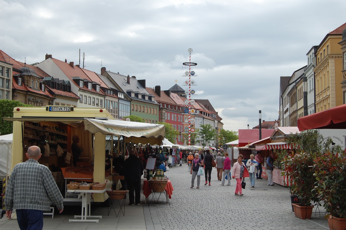 Blick auf den Markt mit verschiedenen Buden und dem Maibaum