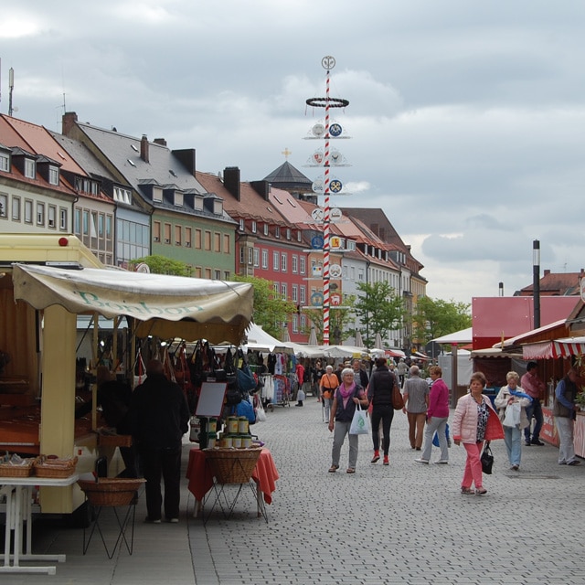 Blick auf den Markt mit verschiedenen Buden und dem Maibaum