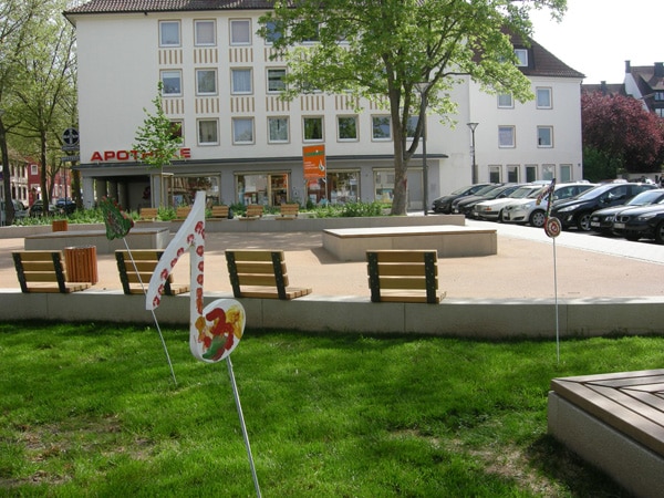 Foto Tekirdagplatz im Vordergrund Wiese mit Skulpturen, dahinter freier Platz mit Sitzinseln und Sitzblöcken