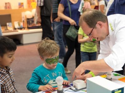 Zwei Kinder bringen eine Glühbirne zum Leuchten auf dem Lernfest in Bayreuth