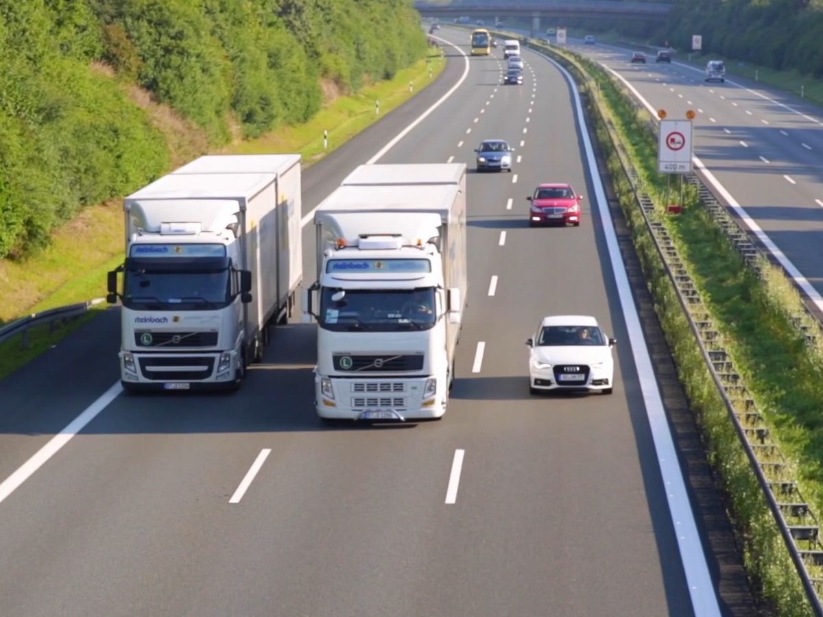 Dreispurige Autobahn mit zwei LKWs der Spedition Steinbach