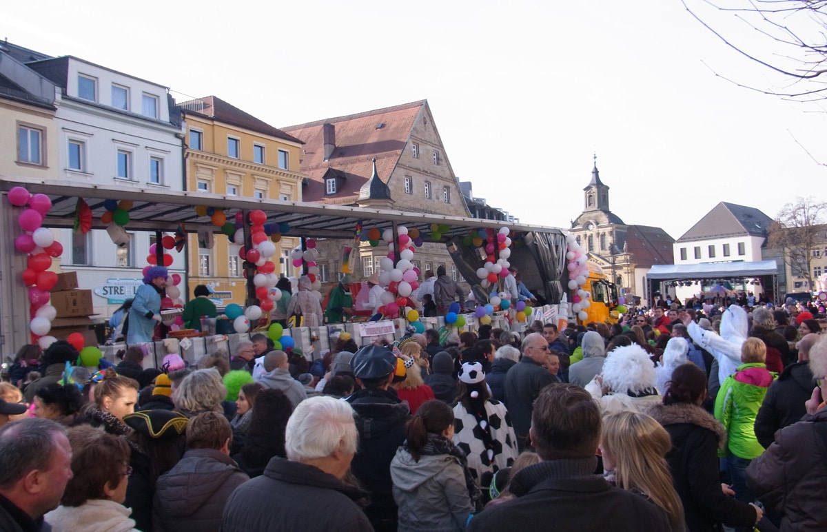 Eine dicht gedrängte Menschenmenge verfolgt den Faschingsumzug durch die Fußgängerzone.