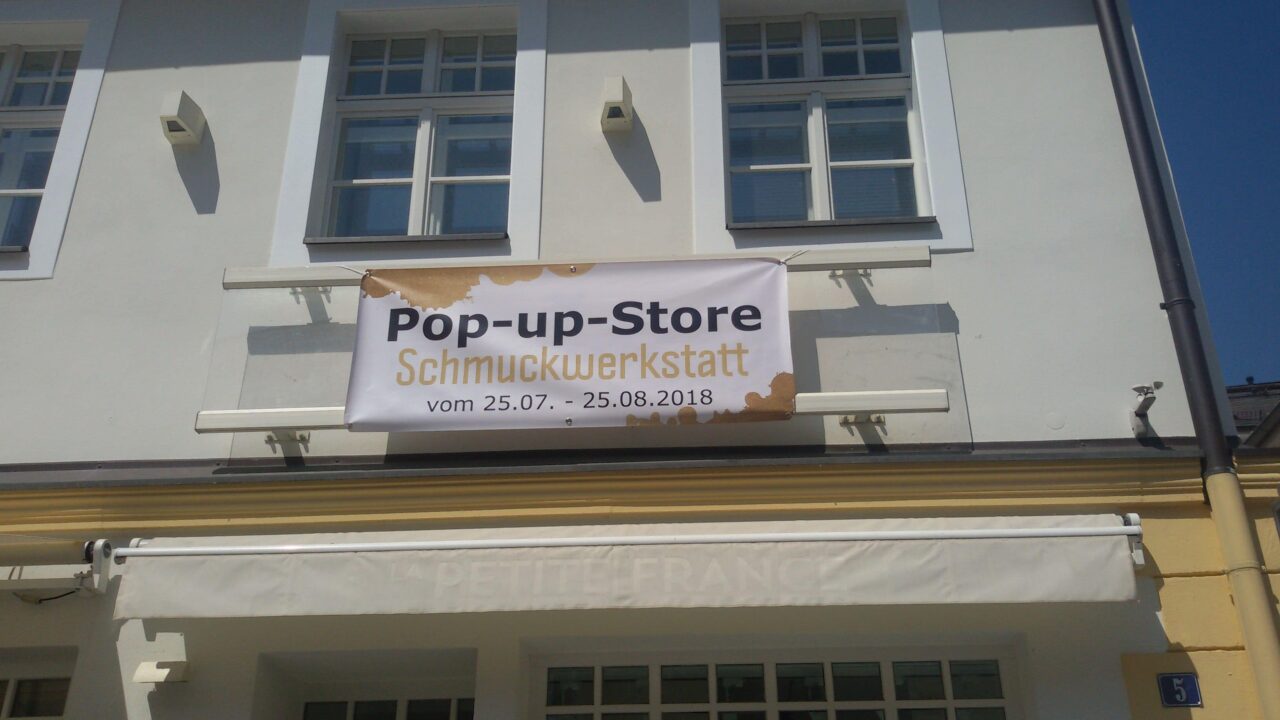 Hauswand mit einem Banner auf dem "Pop-up-Store" steht