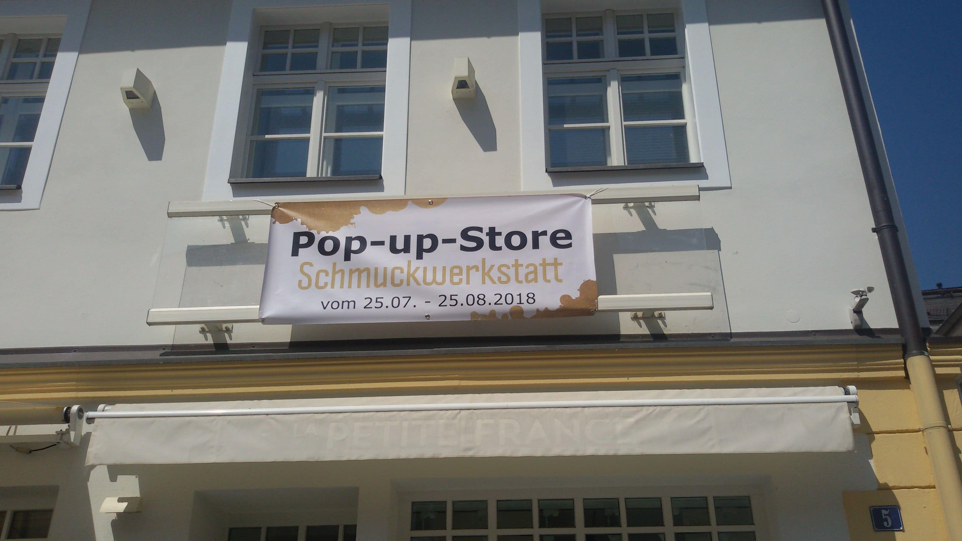 Hauswand mit einem Banner auf dem "Pop-up-Store" steht