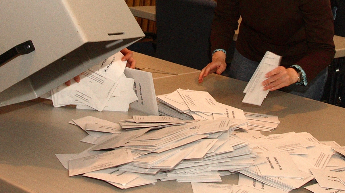 Stimmzettel werden aus einer Urne ausgeschüttet.
