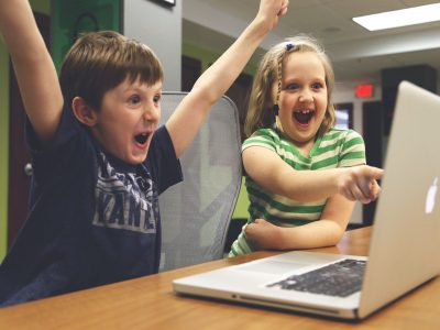Zwei Kinder sitzen vor einem Laptop