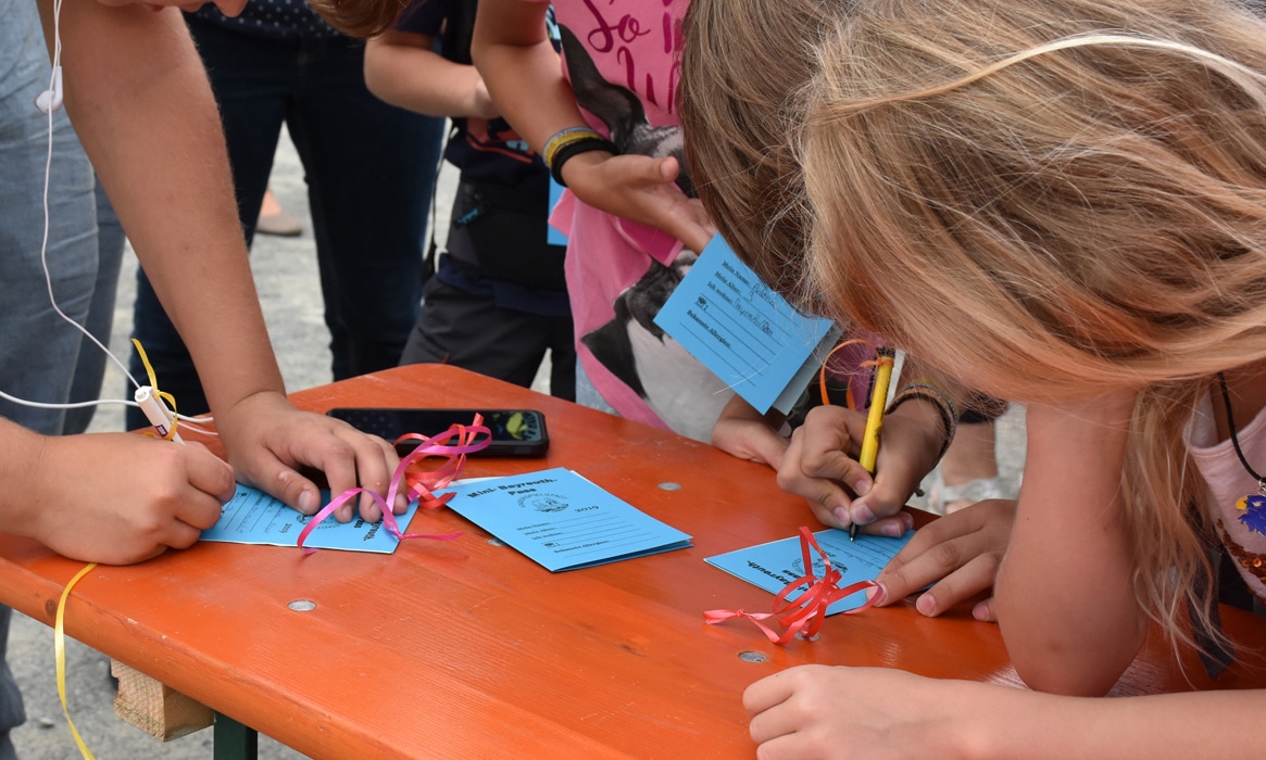 Kinder füllen ihren Pass für Mini-Bayreuth aus.