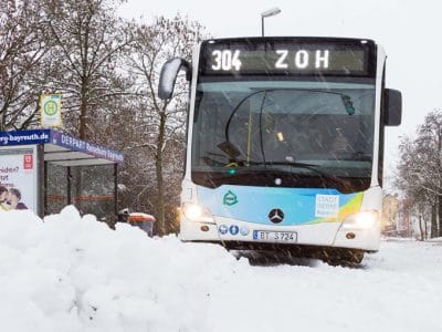 Stadtbus auf schneebedeckter Straße.
