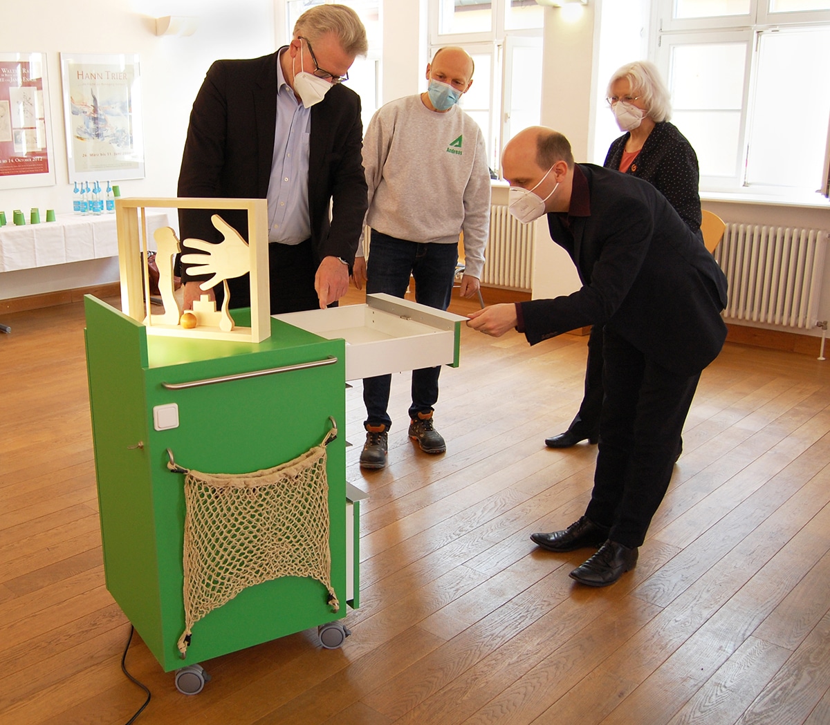 Oberbürgermeister Thomas Ebersberger (links) und Kulturreferent Benedikt Stegmayer erkunden den neuen Inklusions-Trolley für das Kunstmuseum. Museumsleiterin Dr. Marina von Assel und Schreiner Andreas Angermann erklären die einzelnen Funktionen.