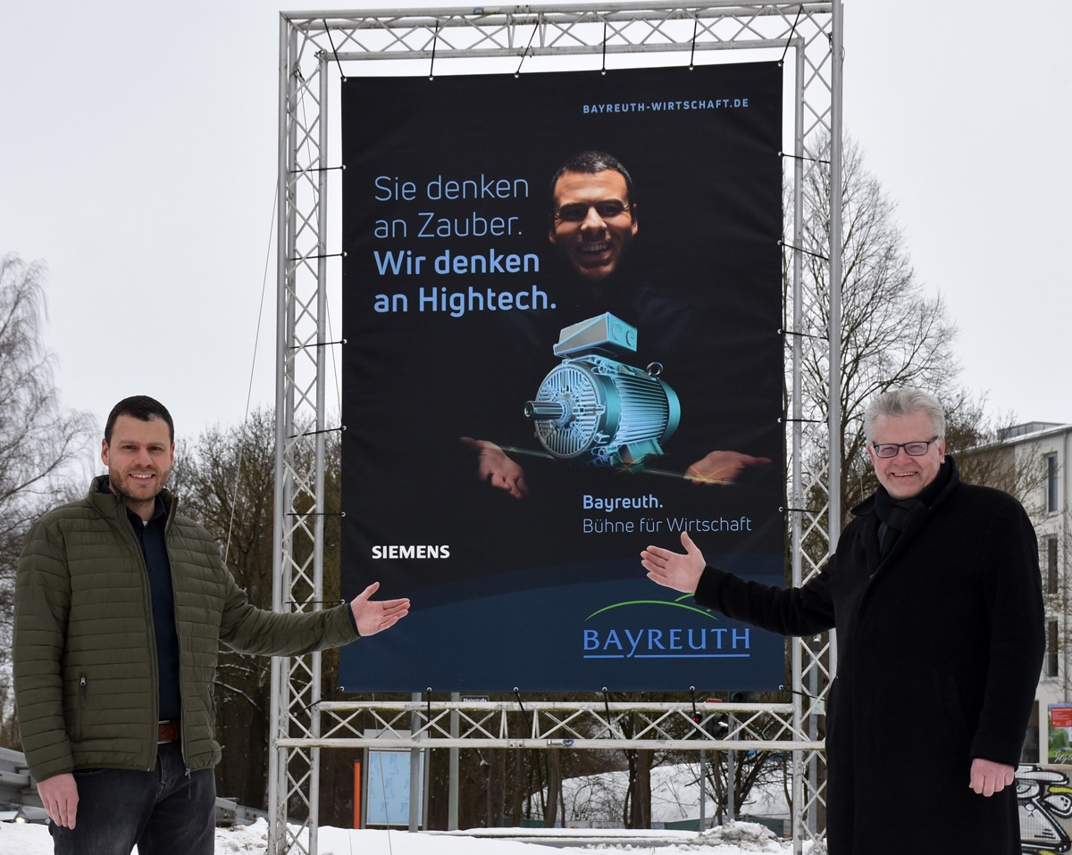 Dominik Herrmann (Siemens) und Oberbürgermeister Ebersberger vor einer Großplakatwand der Kampagne "Bayreuth. Bühne für Wirtschaft".