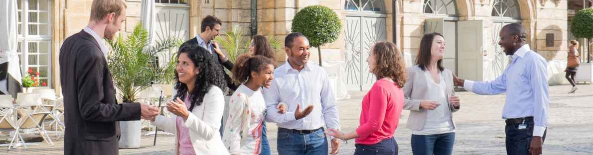 Neue Bürgerinnen und Bürger im Gespräch vor dem Opernhaus