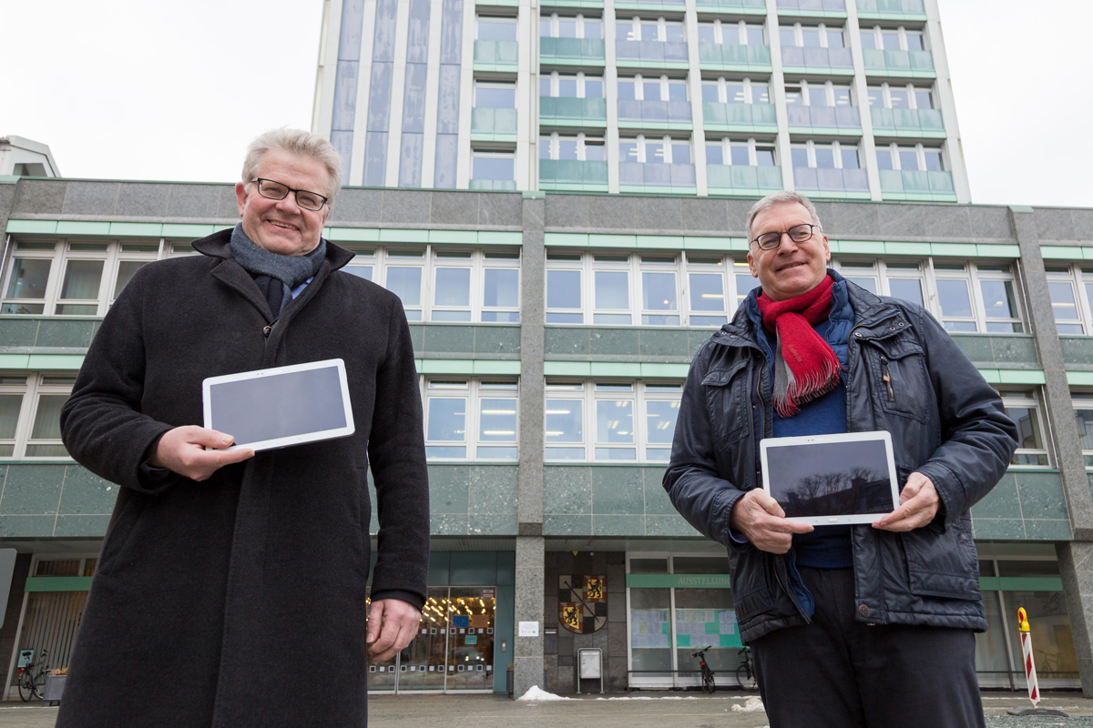 Oberbürgermeister Thomas Ebersberger und Jürgen Bayer von den Stadtwerken mit Tablets vor dem Rathaus.