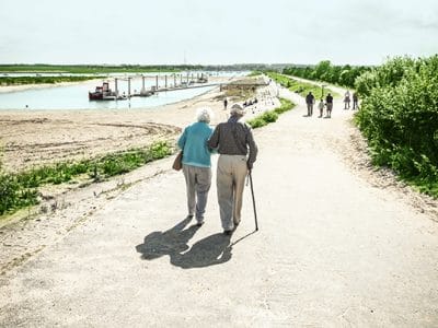 Ein älteres Paar läuft einen Weg entlang