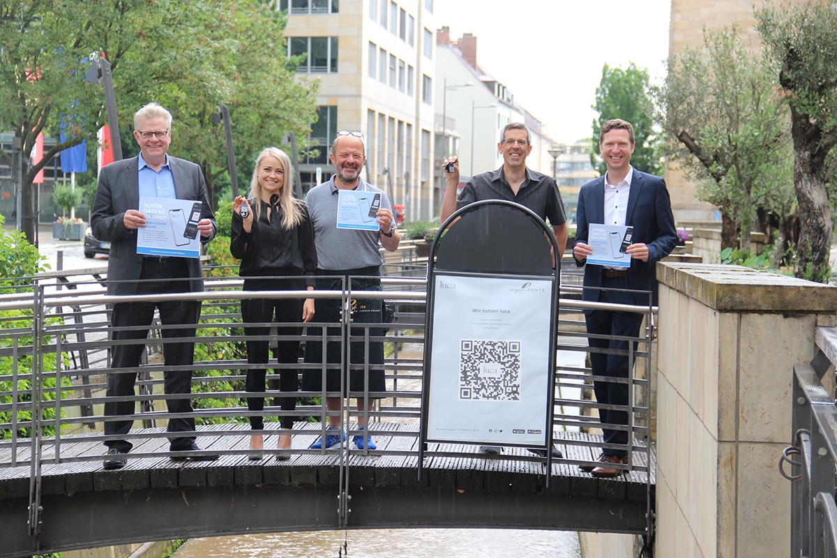 ): Oberbürgermeister Thomas Ebersberger, Jana-Lisa Mönch (Wirtschaftsförderung Landkreis Bayreuth), DEHOGA-Kreisvorsitzender Engin Gülyaprak, Matthias Mörk (Wirtschaftsförderung Stadt Bayreuth) und Landrat Florian Wiedemann zeigen Schlüsselanhänger und Aufkleber.