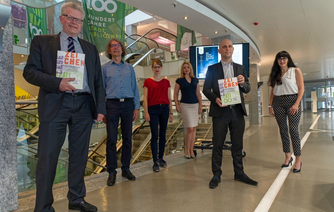 Durch die ersten beiden Vorabexemplare blätterten beim Fototermin Thomas Ebersberger (Oberbürgermeister der Stadt Bayreuth) und Benedikt M. Stegmayer (Kulturreferent) zusammen mit der Leitung der Stadtbibliothek, Jörg Weinreich, Bianka Hoffmann (stellvertretende Leitung), Anne Ulmer (Leitung der Kinderbibliothek) und Monika Pellkofer (Verantwortliche für die Programm- und Öffentlichkeitsarbeit).