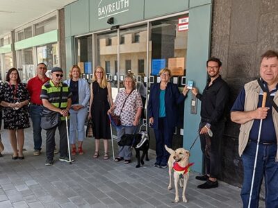 Mehrere Menschen stehen vor dem Rathaus.