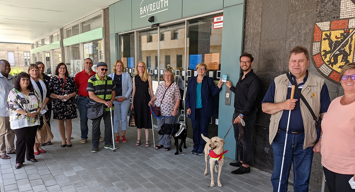 Mehrere Menschen stehen vor dem Rathaus.