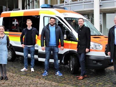 Das Foto zeigt (v.l.) Roland Thiem (Impfkoordination, Landratsamt Bayreuth), Karin Czerwinski (Gesundheitsamt Bayreuth), Markus Huttner (stellvertr. Leiter Rettungsdienst, SKS-Ambulanz), Korbinian Specht (Geschäftsführer, SKS-Ambulanz), Landrat Florian Wiedemann und Oberbürgermeister Thomas Ebersberger vor einem Rettungsfahrzeug der SKS-Ambulanz.