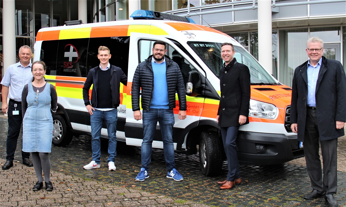 Das Foto zeigt (v.l.) Roland Thiem (Impfkoordination, Landratsamt Bayreuth), Karin Czerwinski (Gesundheitsamt Bayreuth), Markus Huttner (stellvertr. Leiter Rettungsdienst, SKS-Ambulanz), Korbinian Specht (Geschäftsführer, SKS-Ambulanz), Landrat Florian Wiedemann und Oberbürgermeister Thomas Ebersberger vor einem Rettungsfahrzeug der SKS-Ambulanz.