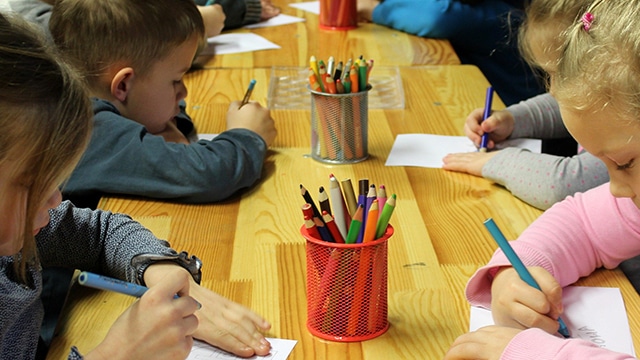 Kinder malen an einem Tisch