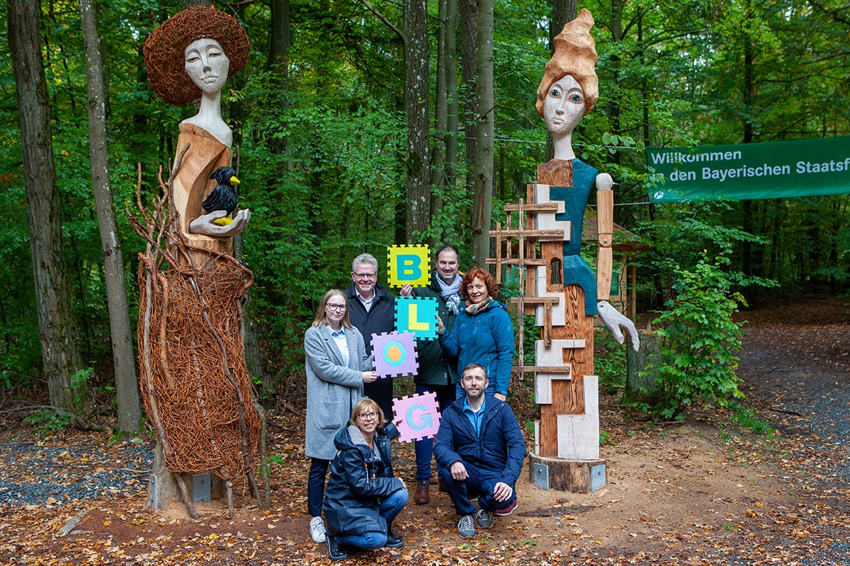 Das Foto zeigt (von links) Irmhild Helldörfer (Jugendamt), Neele Boderius (Bloggerin), Oberbürgermeister Thomas Ebersberger, Stefan Greißinger (Stadtjugendring), Siglinde Seidler-Rieß (Jugendamt) und Jakob Baumgartner (Media Experts) am Eingang des neuen Walderlebnispfades – der auch in einem Blogbeitrag als Ausflugstipp vorgestellt wird.