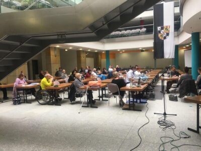 Seitenansicht des gefüllten Sitzungssaals im Atrium der Schlossgalerie während der Rede des Vorsitzenden.