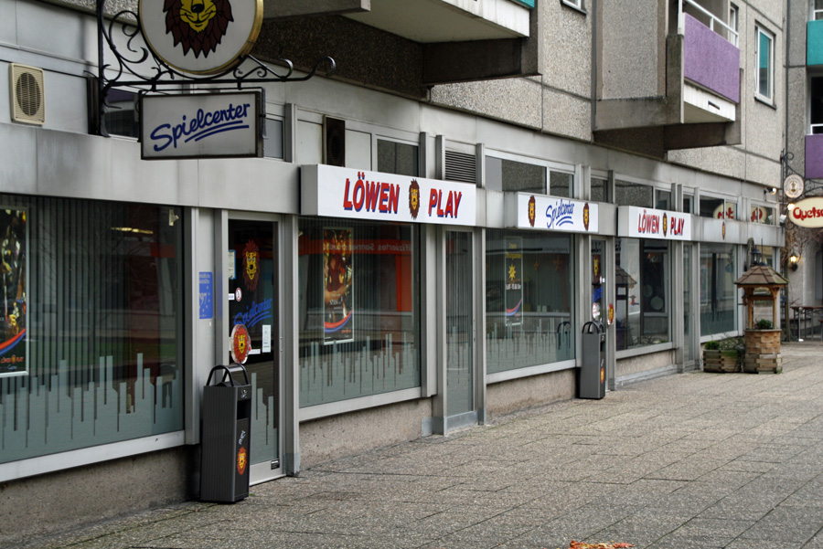 Gebäude am Josephsplatz mit folierten Fensterscheiben, Werbetafeln im Schaufenster und Leuchtwerbung