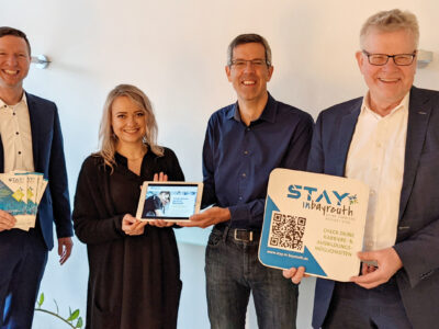 Landrat Wiedemann, OB Ebersberger und zwei Mitarbeiter präsentieren Werbematerialien für die Plattform "Stay in Bayreuth".