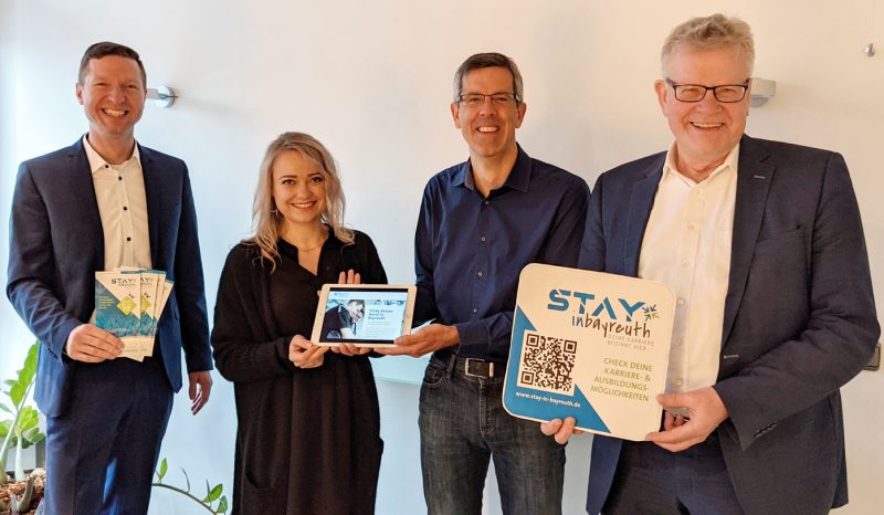 Landrat Wiedemann, OB Ebersberger und zwei Mitarbeiter mit Werbematerialien für die Online-Plattform "Stay in Bayreuth".