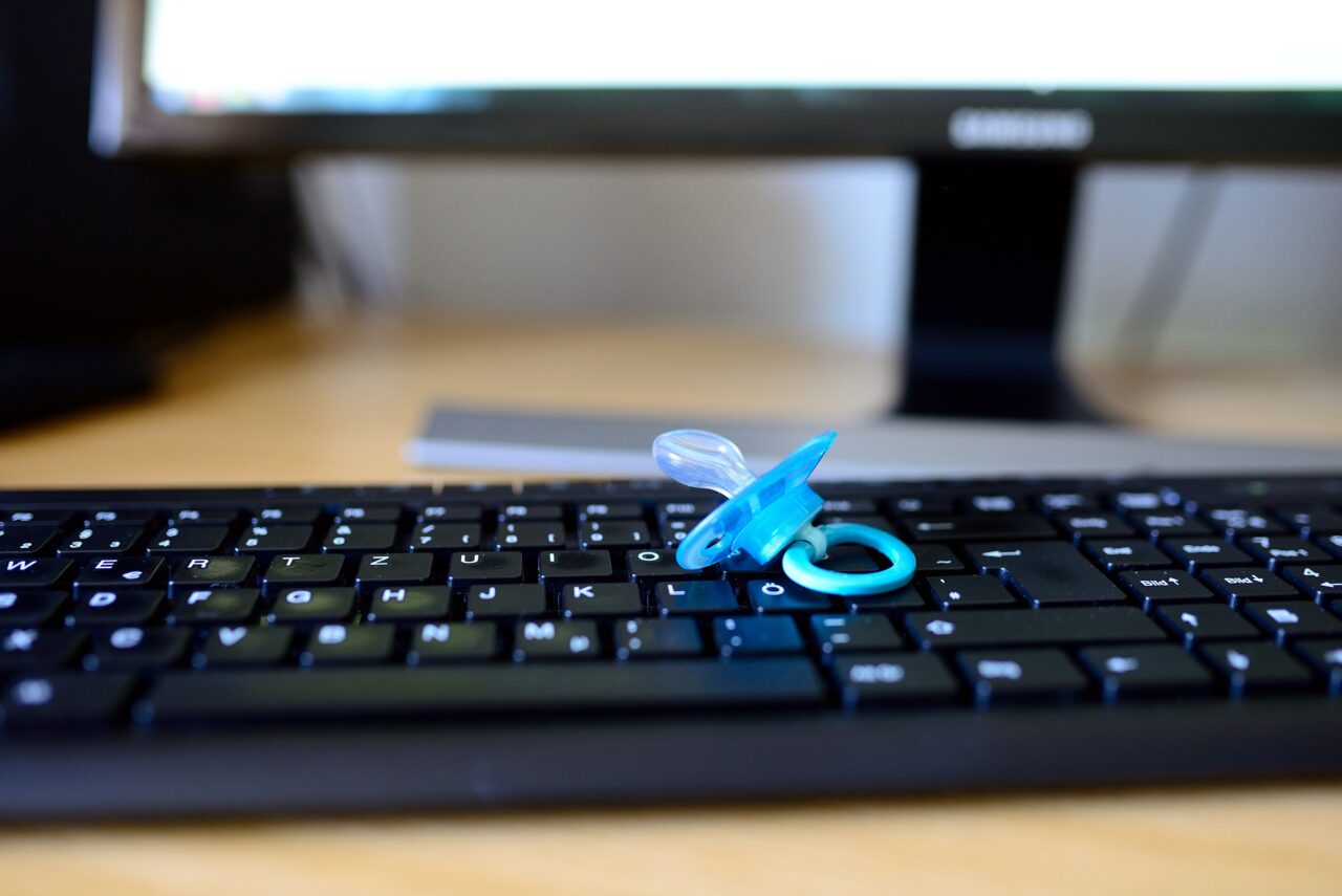 Ein Schnuller liegt auf einer PC-Tastatur.