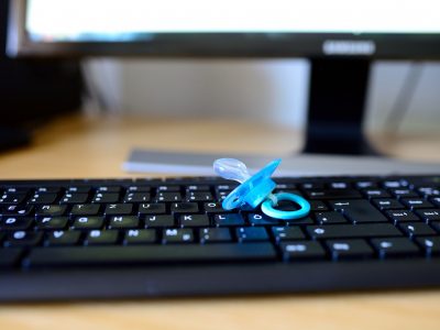 Ein Schnuller liegt auf einer PC-Tastatur.
