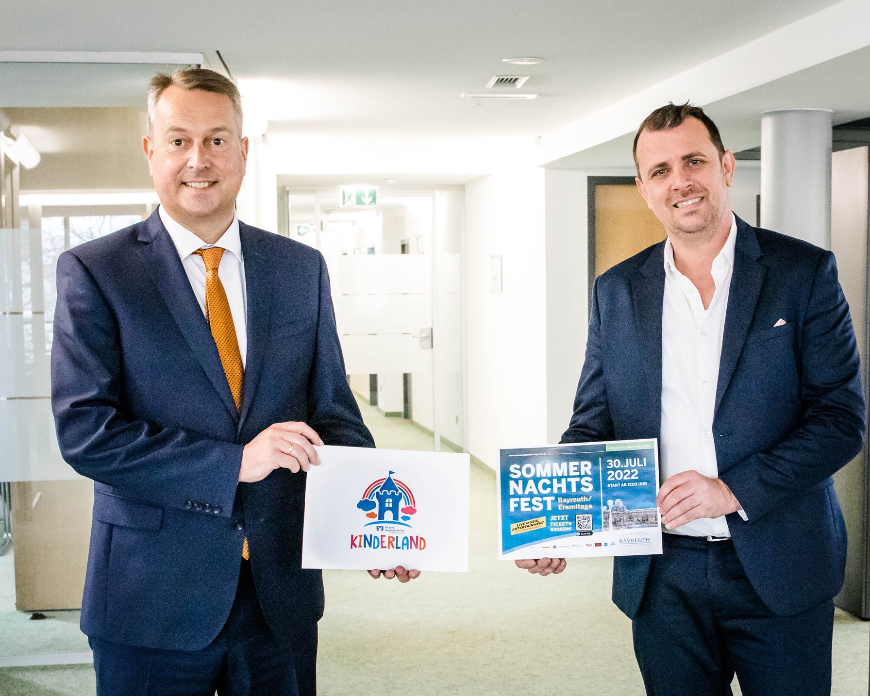 Jürgen Dünkel, Vorstand VR Bank Bayreuth-Hof, und Mario Brunner von der BMTG mit Werbematerialien für das Sommernachtsfest.