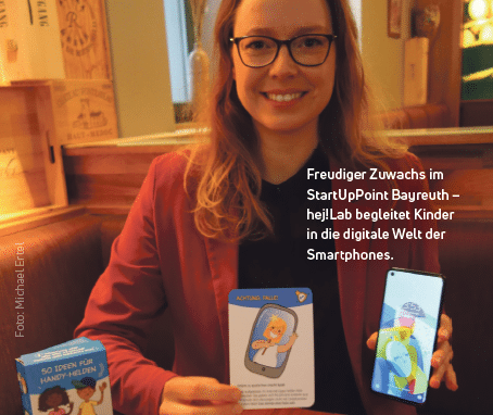 Die Gründerin des Startups hej!LAB hält Kartenspiele in der Hand