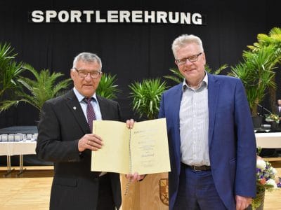 Roland Dörfler und OB Thomas Ebersberger halten eine Urkunde.