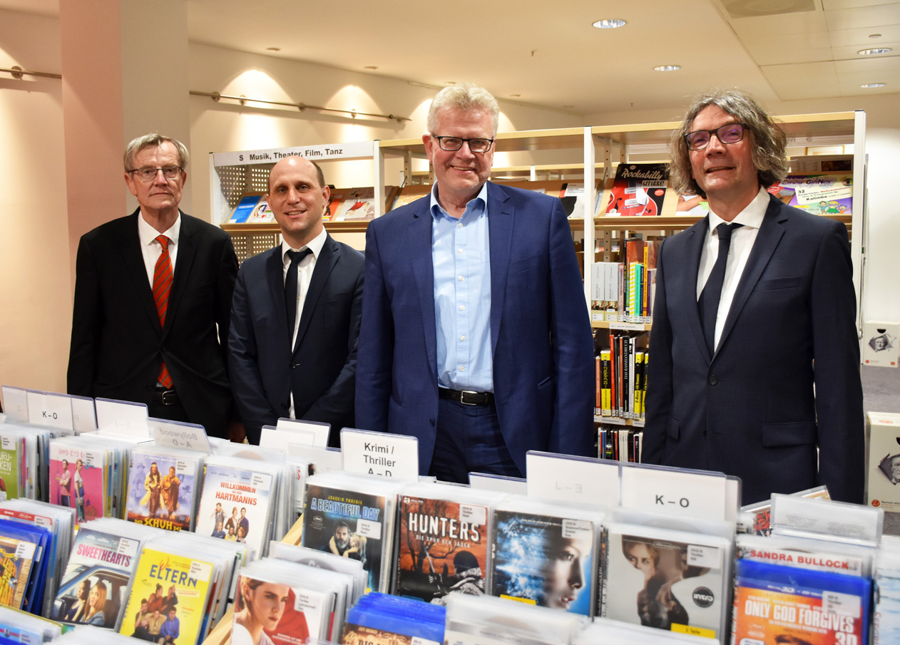 Dr. Harald Rehm, Kulturreferent Stegmayer, OB Ebersberger und Bibliotheksleiter Weinreich hinter einem Büchertisch.