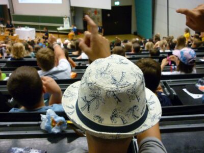 Kinder sitzen in einem Vorlesungssaal der Universität Bayreuth.