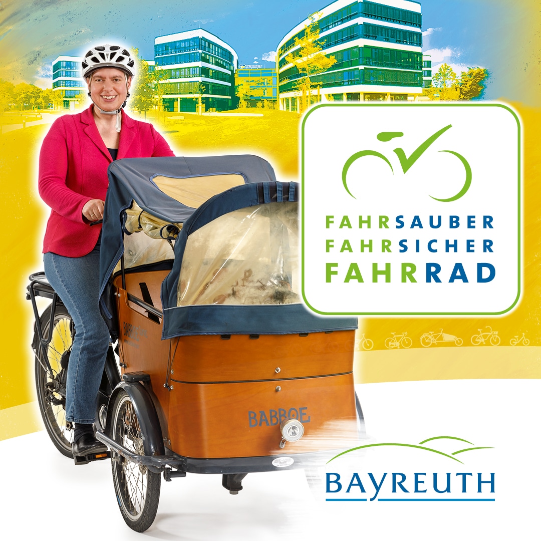 Eine Frau mit Fahrradhelm sitzt auf einem bepackten Lastenrad.