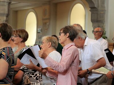 Menschen haben ein Musikblatt in der Hand und singen gemeinsam im Chor