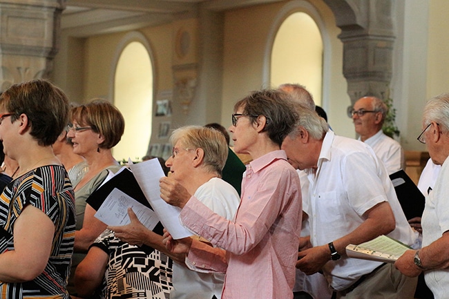Menschen haben ein Musikblatt in der Hand und singen gemeinsam im Chor