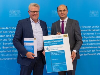 OB Ebersberger und Minister Füracker halten den Förderbescheid in der Hand