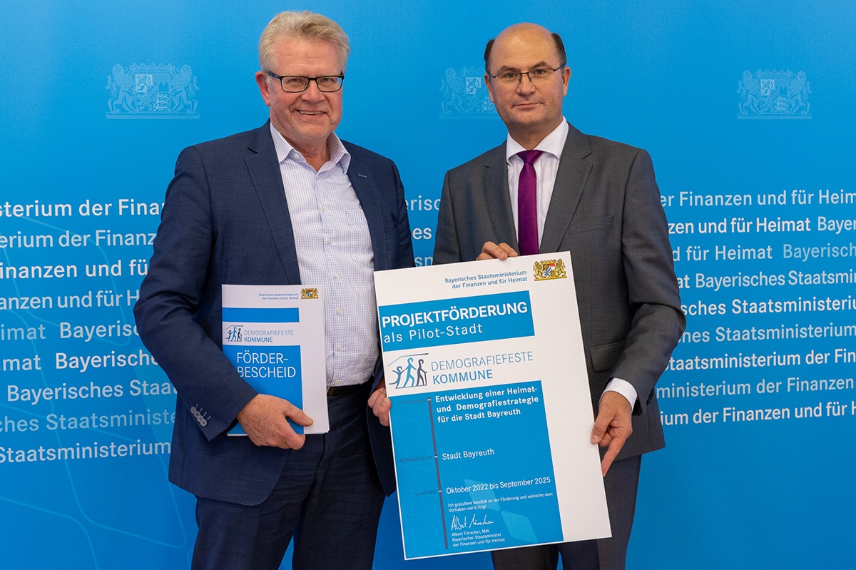 OB Ebersberger und Minister Füracker halten den Förderbescheid in der Hand