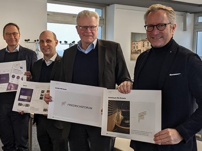 Hendrik Schröder, Benedikt M. Stegmayer, OB Thomas Ebersberger und Jörg Lichtenegger halten Plakate mit dem Logo und anderen Gestaltungselementen in der Hand.