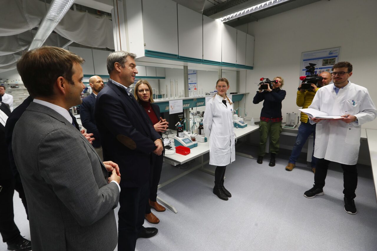 2) Ministerpräsident Dr. Markus Söder (3. v. l.) macht sich vor Ort ein Bild von den Arbeiten am BayBatt, Universitätskanzlerin Dr. Nicole Kaiser (rechts daneben) erläutert Details zum BayBatt.