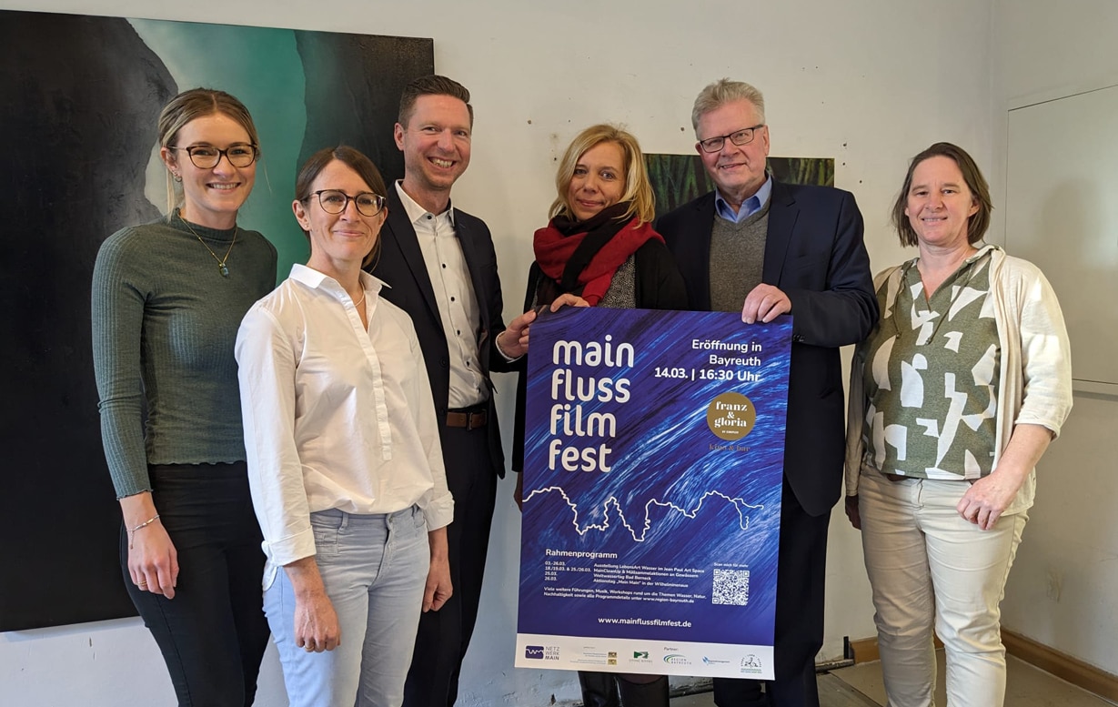 Landrat Wiedemann, OB Ebersberger und ein Projektteam präsentieren das Plakat des Main FlussFilmFestes.
