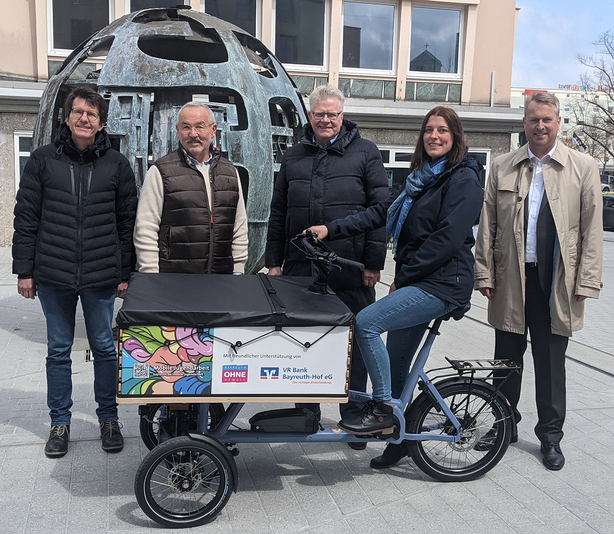109 Lastenrad für Jugendarbeit-3 Heiko Sollmann (Jugendamt), Peter Müller (Verein „Bayreuth ohne Gewalt“), Oberbürgermeister Thomas Ebersberger, Tanja Gardomsky (Mobile Jugendarbeit) und Jürgen Dünkel (Vorstand der VR-Bank Bayreuth-Hof) stehen um das Fahrrad herum.