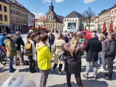 Teilnehmer des Innenstadtspaziergang tauschen sich aus am Stadtparkett, im Hintergrund Spitalkiche und DEPOT