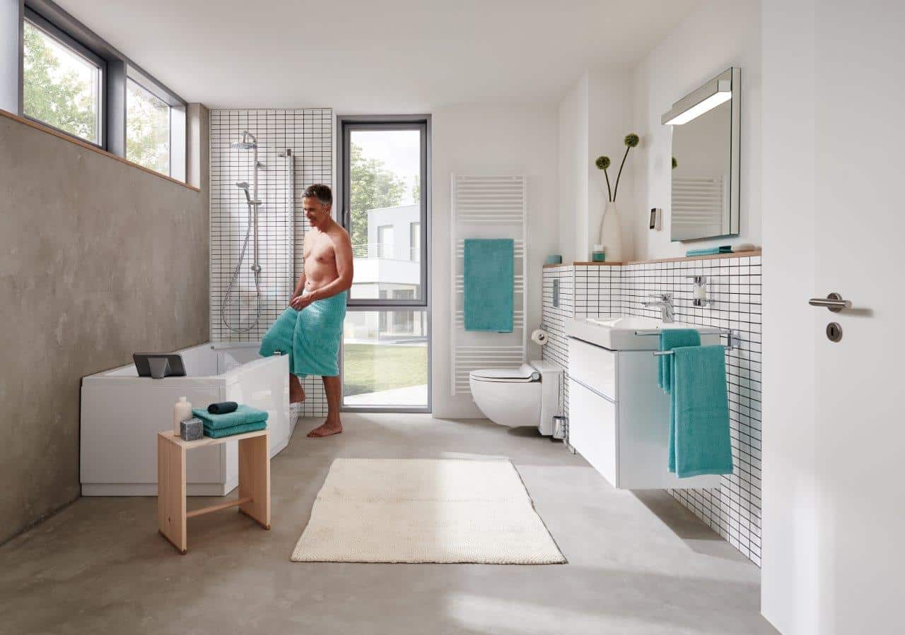 Ein Mann steigt in einem Badezimmer in eine Badewanne. | Foto: Hassmann KG