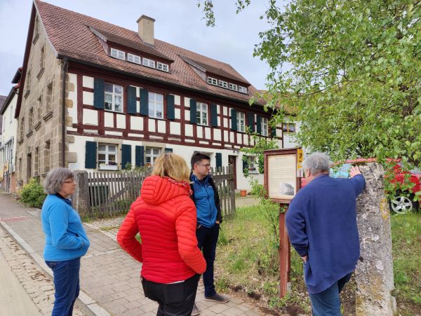 Menschen vor einem Fachwerkhaus