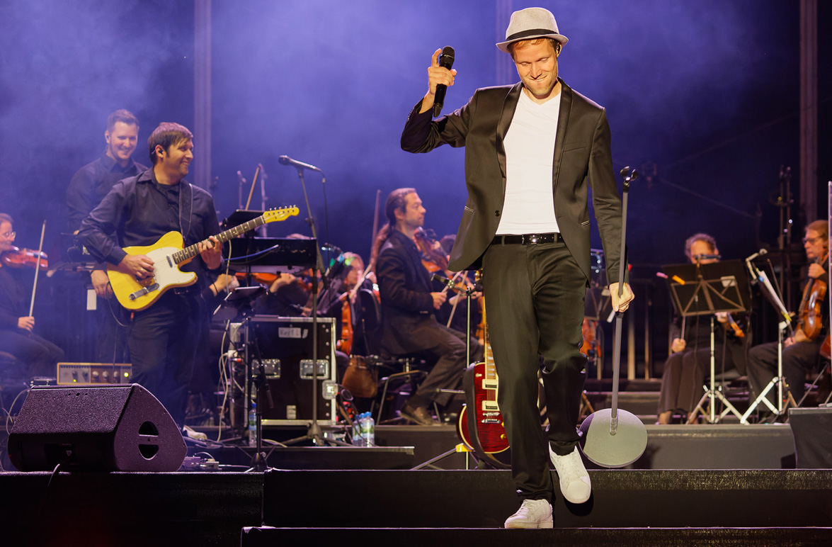 Thomas Hahn mit Mikro auf der Bühne, im Hintergrund Bandmusiker. | Foto: Thüringen Philharmonie