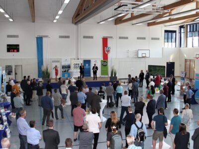 Zahlreiche Zuhörer stehen vor einem Podium in einer großen Halle. | Foto: Landratsamt Hof